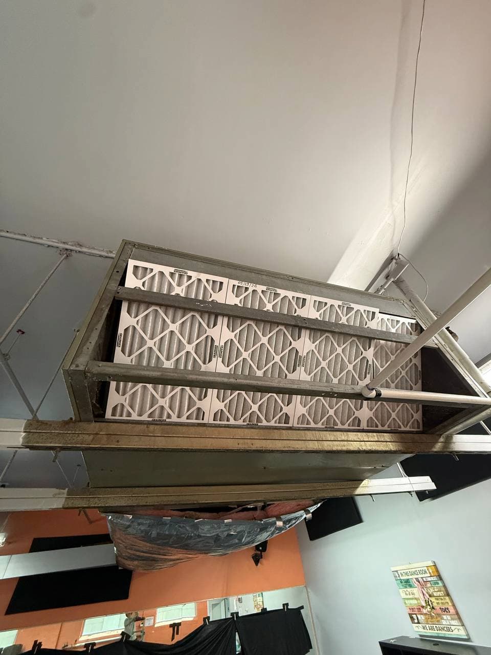 Indoor commercial HVAC filter bank inspected during maintenance