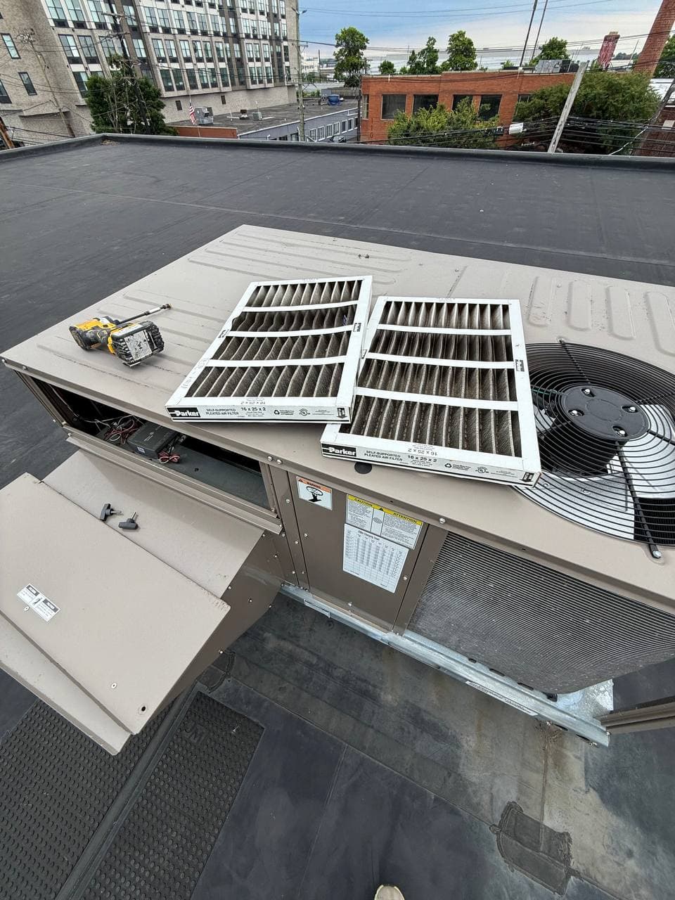 Open commercial rooftop HVAC unit panel during maintenance