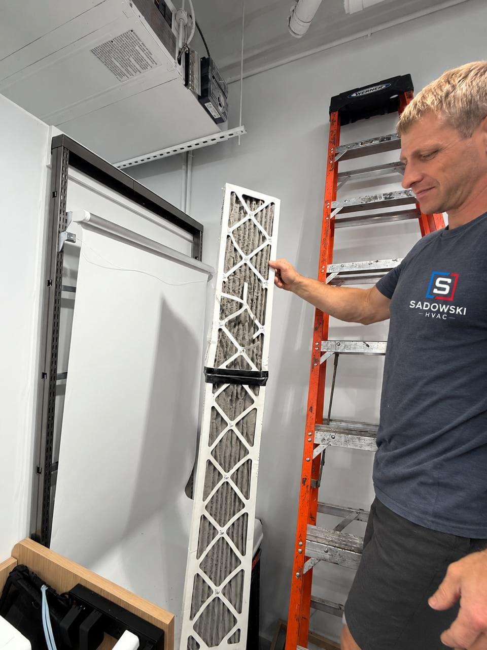 Sadowski HVAC technician inspecting a commercial air filter before installation