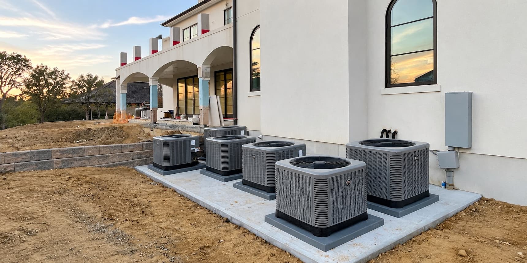 Outdoor air conditioning condenser units beside a home