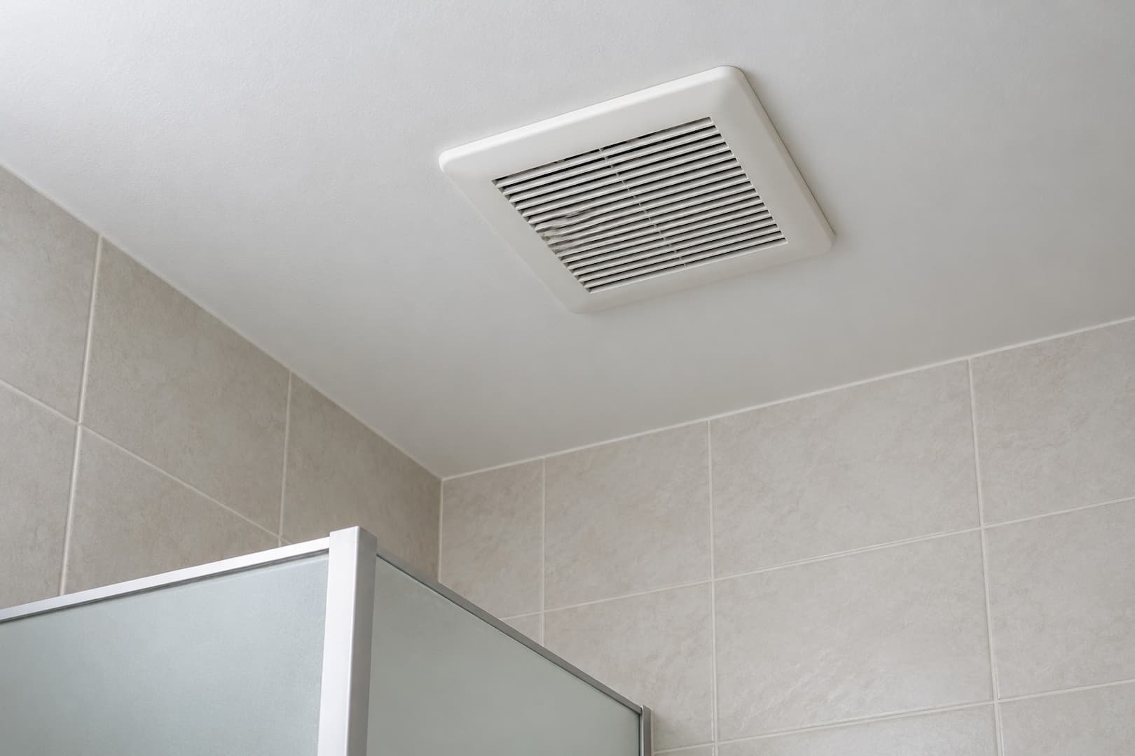 Closed bathroom exhaust-fan grille in a residential ceiling